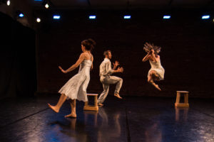 3 dancers performing. One is jump into the air. The other 2 have 1 leg raised.