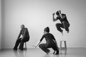 3 dancers performing. One is jumping into the air.