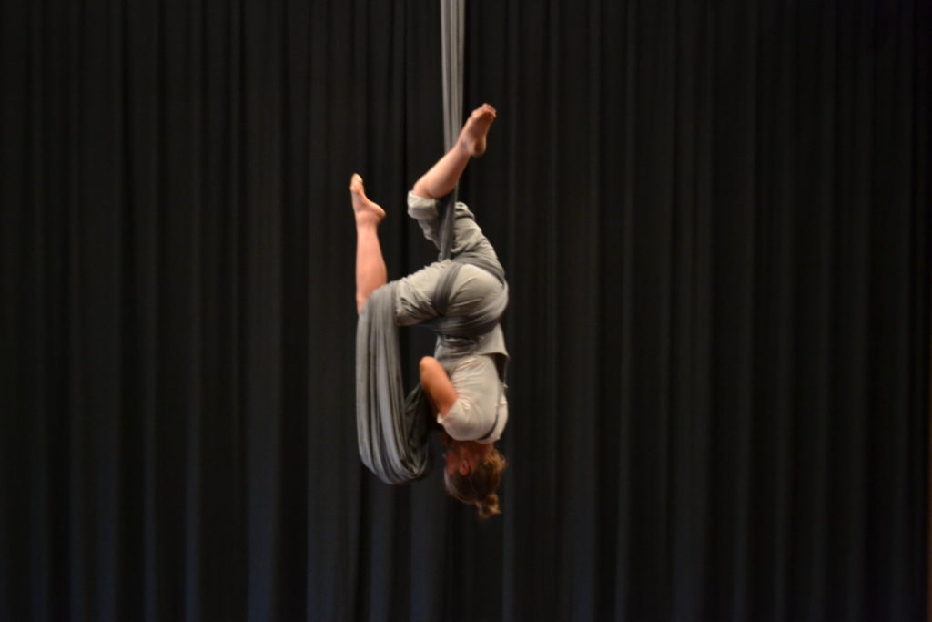 Nicole Malbeuf hanging from silk upside down.