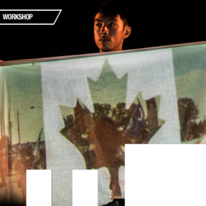 Kevin Matthew Wong hols a piece of fabric, onto which is projected a Canadian glaf with photos of protesters replacing the red portion of the flag