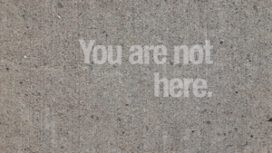 The words "You Are Not Here" appear translucent over concrete.