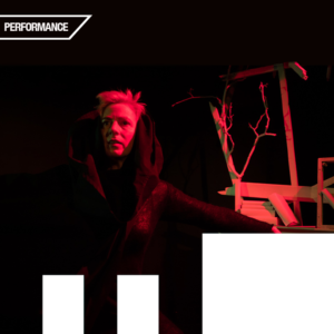 Individual (left side of image) looks into distance, holding arm out to right side with book dangling from hand. Interesting and precarious looking bookshelf (right side of image). Black background with red light on individual and bookshelf. Text reads: Performance.